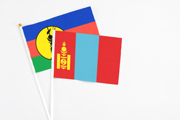 Mongolia and New Caledonia stick flags on white background. High quality fabric, miniature national flag. Peaceful global concept.White floor for copy space.