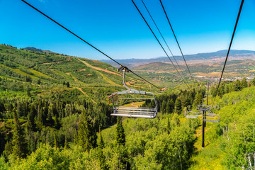 Off season at Park City ski resort with chairlifts over mountain and greenery