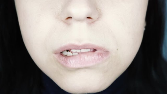 A young woman bites her lips. Close up.