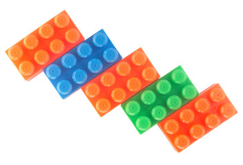  five blocks of orange, blue and green children’s constructors built by a ladder. isolate on white background. Flat lay