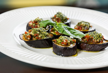 Backed aubergine slices with chopped vegetables topping