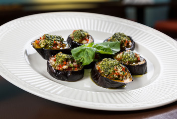 Backed aubergine slices with chopped vegetables topping