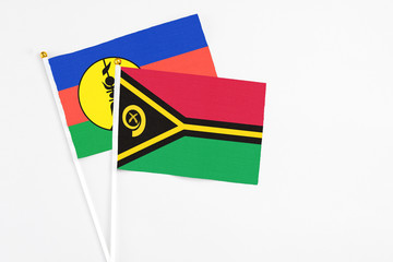 Vanuatu and New Caledonia stick flags on white background. High quality fabric, miniature national flag. Peaceful global concept.White floor for copy space.