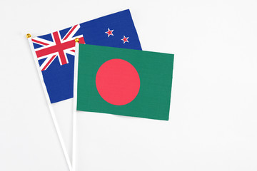 Bangladesh and New Zealand stick flags on white background. High quality fabric, miniature national flag. Peaceful global concept.White floor for copy space.