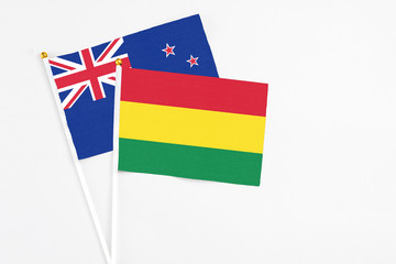 Bolivia and New Zealand stick flags on white background. High quality fabric, miniature national flag. Peaceful global concept.White floor for copy space.