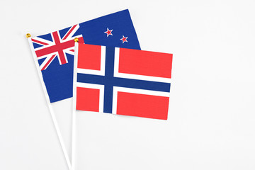 Fototapeta premium Bouvet Islands and New Zealand stick flags on white background. High quality fabric, miniature national flag. Peaceful global concept.White floor for copy space.