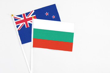 Bulgaria and New Zealand stick flags on white background. High quality fabric, miniature national flag. Peaceful global concept.White floor for copy space.