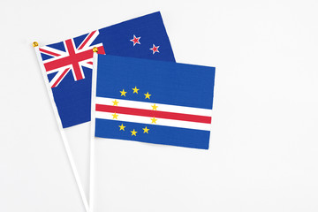 Fototapeta premium Cape Verde and New Zealand stick flags on white background. High quality fabric, miniature national flag. Peaceful global concept.White floor for copy space.