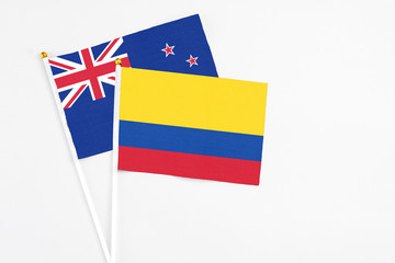 Colombia and New Zealand stick flags on white background. High quality fabric, miniature national flag. Peaceful global concept.White floor for copy space.