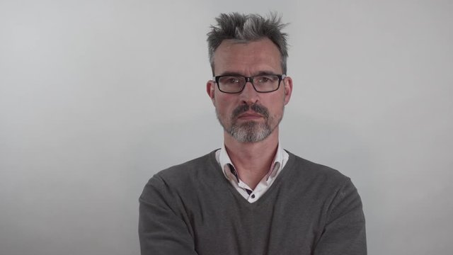 Mann mittleren Altern setzt seine Brille ab und auf