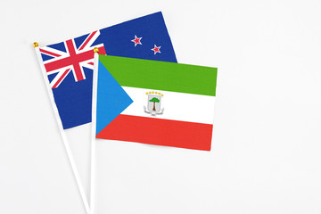 Equatorial Guinea and New Zealand stick flags on white background. High quality fabric, miniature national flag. Peaceful global concept.White floor for copy space.