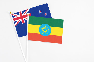 Ethiopia and New Zealand stick flags on white background. High quality fabric, miniature national flag. Peaceful global concept.White floor for copy space.