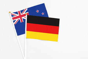 Germany and New Zealand stick flags on white background. High quality fabric, miniature national flag. Peaceful global concept.White floor for copy space.