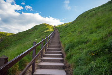 Fototapeta na wymiar Deserted hillside stairway along a coastal path on a sunny spring day. Aberdeenshire, Scotland, UK.