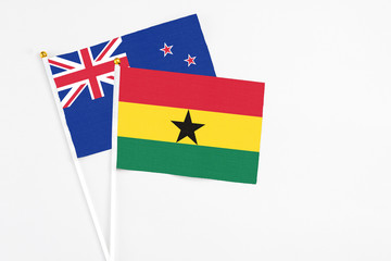 Ghana and New Zealand stick flags on white background. High quality fabric, miniature national flag. Peaceful global concept.White floor for copy space.