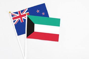 Kuwait and New Zealand stick flags on white background. High quality fabric, miniature national flag. Peaceful global concept.White floor for copy space.