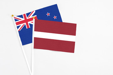 Latvia and New Zealand stick flags on white background. High quality fabric, miniature national flag. Peaceful global concept.White floor for copy space.