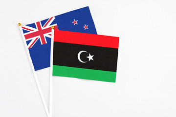 Libya and New Zealand stick flags on white background. High quality fabric, miniature national flag. Peaceful global concept.White floor for copy space.