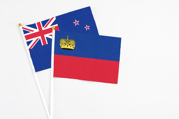 Liechtenstein and New Zealand stick flags on white background. High quality fabric, miniature national flag. Peaceful global concept.White floor for copy space.