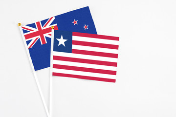 Liberia and New Zealand stick flags on white background. High quality fabric, miniature national flag. Peaceful global concept.White floor for copy space.