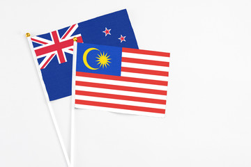Malaysia and New Zealand stick flags on white background. High quality fabric, miniature national flag. Peaceful global concept.White floor for copy space.