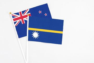 Nauru and New Zealand stick flags on white background. High quality fabric, miniature national flag. Peaceful global concept.White floor for copy space.