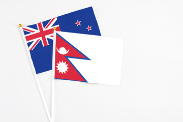 Nepal and New Zealand stick flags on white background. High quality fabric, miniature national flag. Peaceful global concept.White floor for copy space.