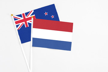 Netherlands and New Zealand stick flags on white background. High quality fabric, miniature national flag. Peaceful global concept.White floor for copy space.