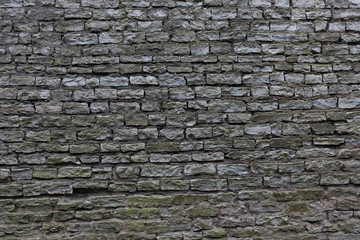 View of the fortress wall of the old city in Tallinn. Estonia. Facing in natural dark gray stone blocks. Background. Texture.