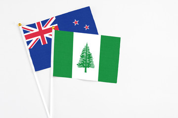 Norfolk Island and New Zealand stick flags on white background. High quality fabric, miniature national flag. Peaceful global concept.White floor for copy space.