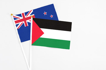 Palestine and New Zealand stick flags on white background. High quality fabric, miniature national flag. Peaceful global concept.White floor for copy space.