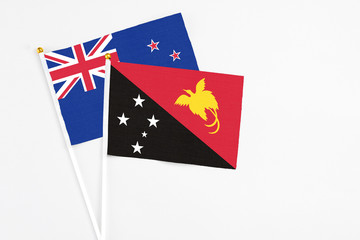 Papua New Guinea and New Zealand stick flags on white background. High quality fabric, miniature national flag. Peaceful global concept.White floor for copy space.