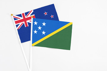 Solomon Islands and New Zealand stick flags on white background. High quality fabric, miniature...