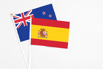 Spain and New Zealand stick flags on white background. High quality fabric, miniature national flag. Peaceful global concept.White floor for copy space.