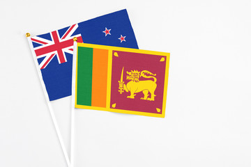 Sri Lanka and New Zealand stick flags on white background. High quality fabric, miniature national flag. Peaceful global concept.White floor for copy space.