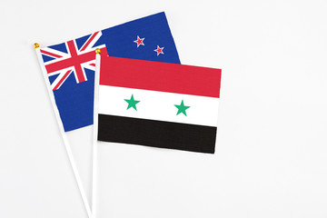 Syria and New Zealand stick flags on white background. High quality fabric, miniature national flag. Peaceful global concept.White floor for copy space.