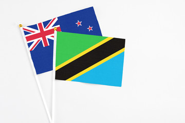 Tanzania and New Zealand stick flags on white background. High quality fabric, miniature national flag. Peaceful global concept.White floor for copy space.