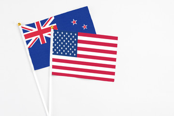 United States and New Zealand stick flags on white background. High quality fabric, miniature national flag. Peaceful global concept.White floor for copy space.