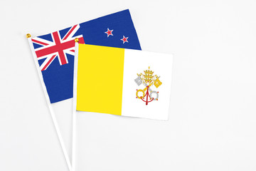 Vatican City and New Zealand stick flags on white background. High quality fabric, miniature national flag. Peaceful global concept.White floor for copy space.