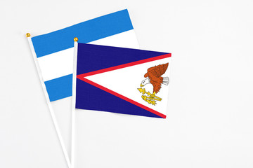 American Samoa and Nicaragua stick flags on white background. High quality fabric, miniature national flag. Peaceful global concept.White floor for copy space.