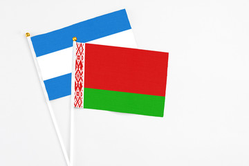 Belarus and Nicaragua stick flags on white background. High quality fabric, miniature national flag. Peaceful global concept.White floor for copy space.