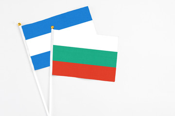 Bulgaria and Nicaragua stick flags on white background. High quality fabric, miniature national flag. Peaceful global concept.White floor for copy space.