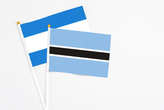 Botswana and Nicaragua stick flags on white background. High quality fabric, miniature national flag. Peaceful global concept.White floor for copy space.