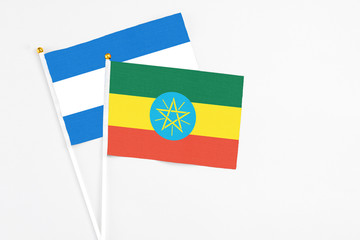 Ethiopia and Nicaragua stick flags on white background. High quality fabric, miniature national flag. Peaceful global concept.White floor for copy space.