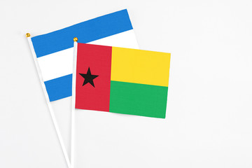 Guinea Bissau and Nicaragua stick flags on white background. High quality fabric, miniature national flag. Peaceful global concept.White floor for copy space.