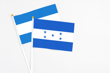 Honduras and Nicaragua stick flags on white background. High quality fabric, miniature national flag. Peaceful global concept.White floor for copy space.