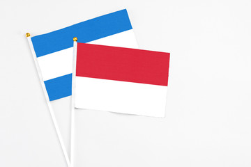Indonesia and Nicaragua stick flags on white background. High quality fabric, miniature national flag. Peaceful global concept.White floor for copy space.