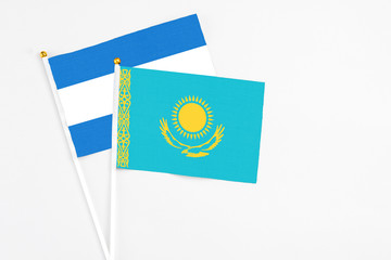 Kazakhstan and Nicaragua stick flags on white background. High quality fabric, miniature national flag. Peaceful global concept.White floor for copy space.