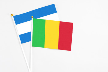 Mali and Nicaragua stick flags on white background. High quality fabric, miniature national flag. Peaceful global concept.White floor for copy space.