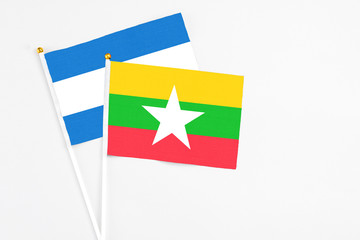 Myanmar and Nicaragua stick flags on white background. High quality fabric, miniature national flag. Peaceful global concept.White floor for copy space.